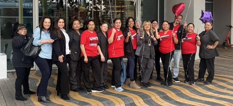 A group of hotel smile and pose in front of the Courtyard by Marriott