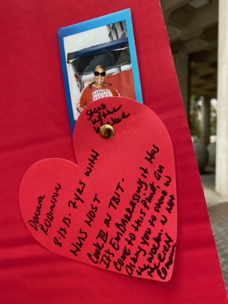 HMS Host at LAX worker Donisa Robinson shares her experience in a poster outside LA City Hall