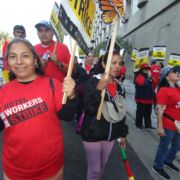 Striking hotel workers carry picket signs