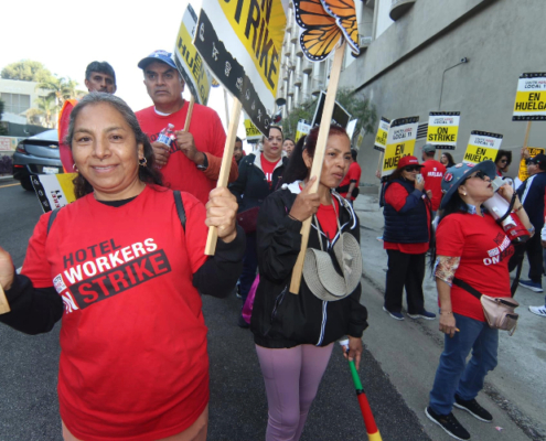 Striking hotel workers carry picket signs