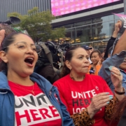 Two women hospitality workers in red t-shirts rally in downtown Los Angeles.