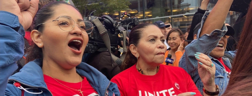 Two women hospitality workers in red t-shirts rally in downtown Los Angeles.